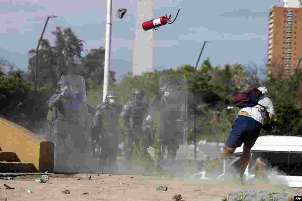 Demonstrators clash with riot police during a protest at Plaza Italia square in Santiago against the Chilean police, Oct. 03, 2020, after Antony Araya, 16, fell from a bridge while police was attempting to arrest him during Friday clashes.
