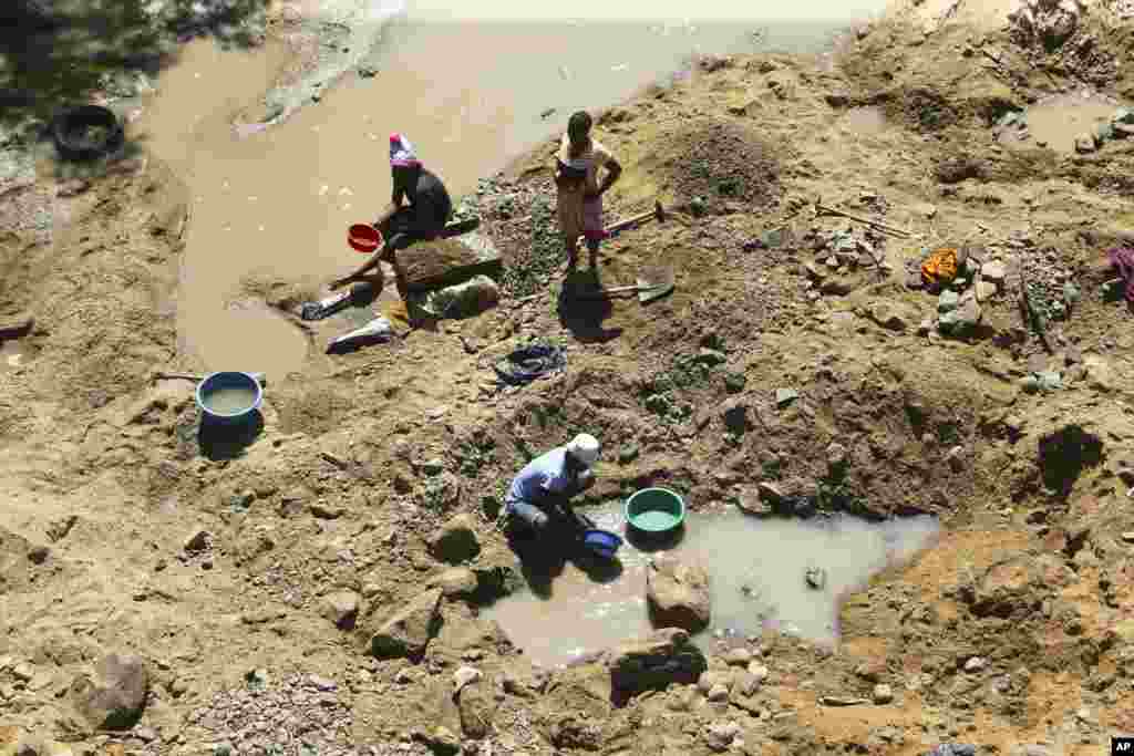 Small scale miners are seen on a river bed on the outskirts of Harare. Zimbabwe’s government says it has banned mining in its national parks.