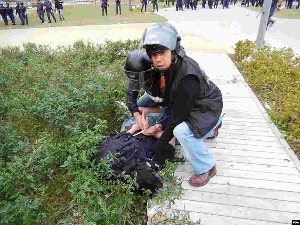 兩名穿上防暴裝備的警員將一名示威者制服按在地上,並以索帶縳上雙手拘捕
