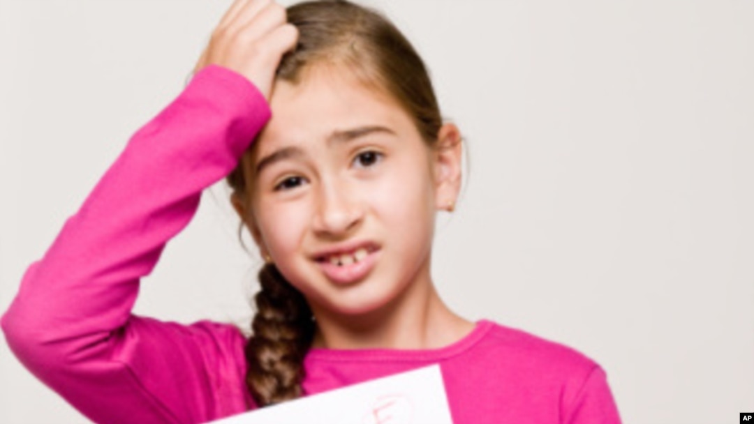 A student holds a test with the failing letter grade of "F."