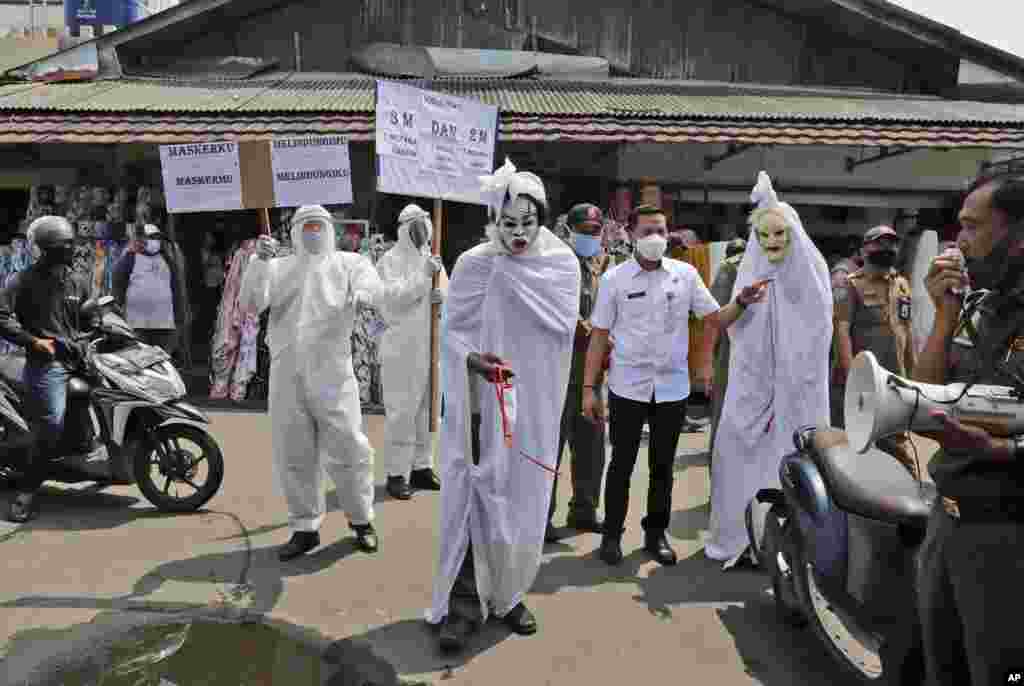 Government officials dressed as a shrouded ghosts, traditionally known as a 'pocong', to represent the victims of COVID-19, take part in a coronavirus awareness campaign at a market in Tangerang, Indonesia.