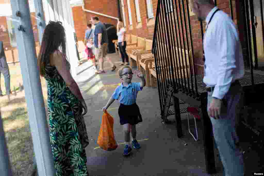 A pupil waves to his teachers as he arrives at St Dunstan's College junior school as some schools re-open following the outbreak of the COVID-19 in London.