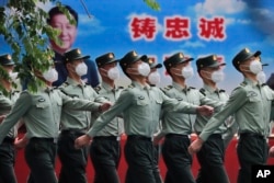 中國武警士兵列隊走過宣傳習近平領導的宣傳畫。（2020年5月25日）