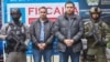 Los hermanos Andres Felipe y Ramen Emilio Perez Hoyos son fotografiados, esposados con escolta policial, tras ser arrestados en Río Negro, Colombia, el 15 de enero de 2023.