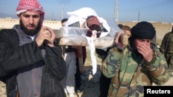 Free Syrian Army fighters carry the body of their comrade who died during clashes with forces loyal to Syria's President Bashar al-Assad, in Qusair town near Homs, March 25, 2013. 