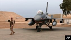 FILE - An Iraqi soldier stands guard near a U.S.-made Iraqi air force F-16 jet at Balad Air Base, north of Baghdad, Iraq, Feb. 13, 2018.
