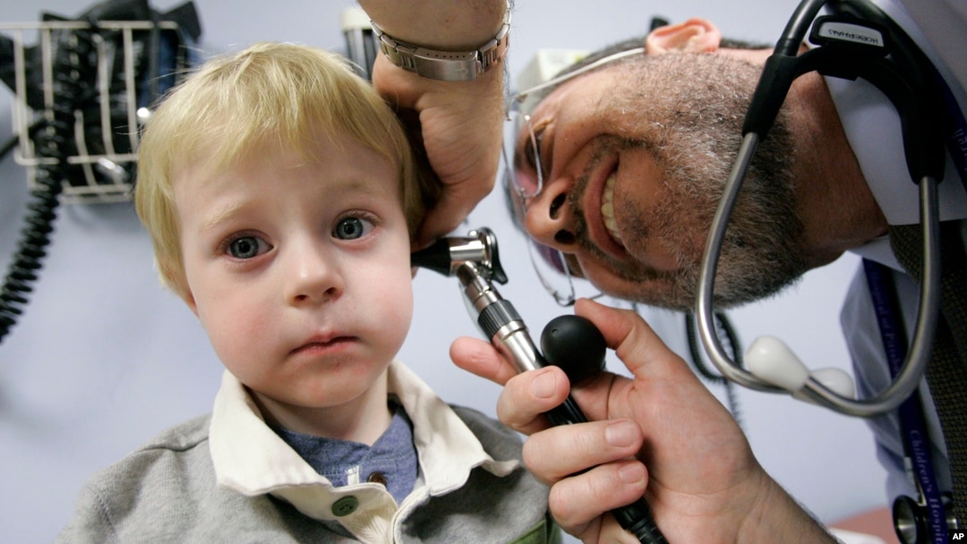 FILE - A child has his ear examined by a doctor at Children's Hospital of Pittsburgh, in Pittsburgh, Nov. 20, 2006.