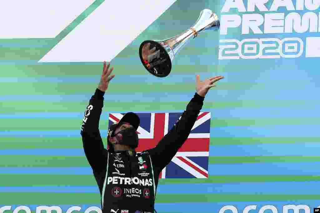 Mercedes driver Lewis Hamilton of Britain throws his trophy after the Formula One Grand Prix at the Barcelona Catalunya racetrack in Montmelo, Spain.