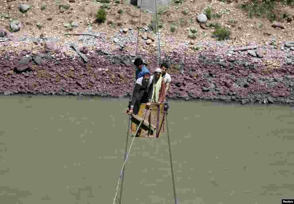 Warga India menyeberangi sungai Chenab untuk mendatangi TPS dalam pemilu di desa Harshi, kabupaten Doda, di kawasan Jammu, India.