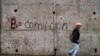 Un hombre pasa por un graffiti que dice "Bitcoin es igual a corrupción", que es parte de una campaña contra el uso del bitcóin como moneda de curso legal, en San Salvador, El Salvador, el 5 de octubre de 2021.
