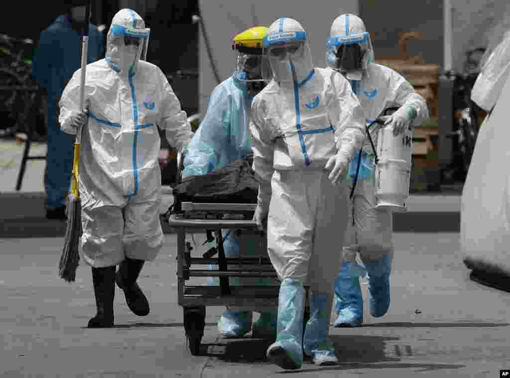Health workers in protective suits transport a dead body at a hospital in Manila, Philippines. The capital and outlying provinces returned to another lockdown after medical groups warned that the country was waging a losing battle against the coronavirus. 