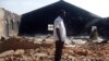 FILE - A picture taken on Jan. 24, 2010, shows a Christian resident of the Nigerian city of Jos standing near a church burnt in ongoing sectarian violence.