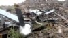 A man stands near the wreckage of a U.S. MQ-9 drone that Houthis claim they shot out of the sky, in a location given as Saada Governorate, Yemen, in this undated still image taken from a video obtained on Aug. 4, 2024. (Houthi Military Media via Reuters)