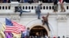 Una turba de simpatizantes del expresidente Donald Trump lucha contra policías en la puerta que rompieron al asaltar el Capitolio en Washington D.C. el 6 de enero pasado.