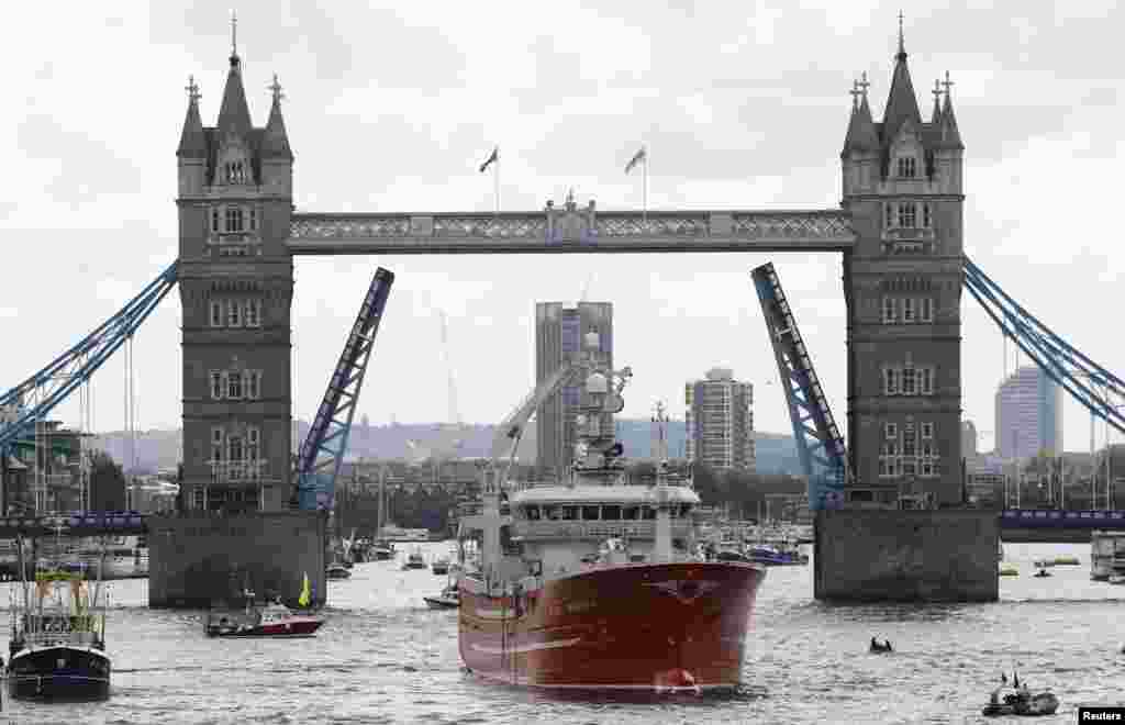Sebuah kapal melewati jembatan London di sungai Thames, London, Inggris.