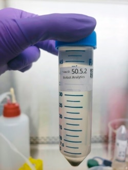 In this undated photo provided by Biobot in June 2020, a technician holds a wastewater sampling tube. Across the U.S. and in Europe, researchers and health officials say they can track the course of a community outbreak by studying the waste flushed from