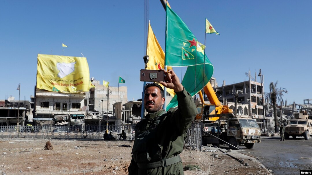A fighter of Syrian Democratic Forces takes a selfie at Naim Roundabout in Raqqa, Syria, Oct. 18, 2017.