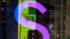 Una mujer usando máscara de protección habla por teléfono frente a una tienda en Ciudad México, México, el 1 de diciembre de 2020.
