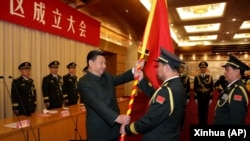 中國國家主席習近平（左前）在北京舉行的中國人民解放軍戰區成立大會上向五大戰區授予軍旗。（2016年2月1日）