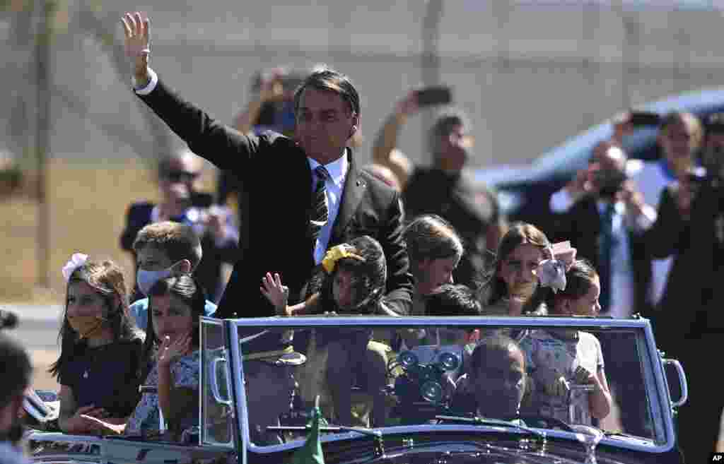 Brazil's President Jair Bolsonaro rides in an open car during an Independence Day event in Brasilia.