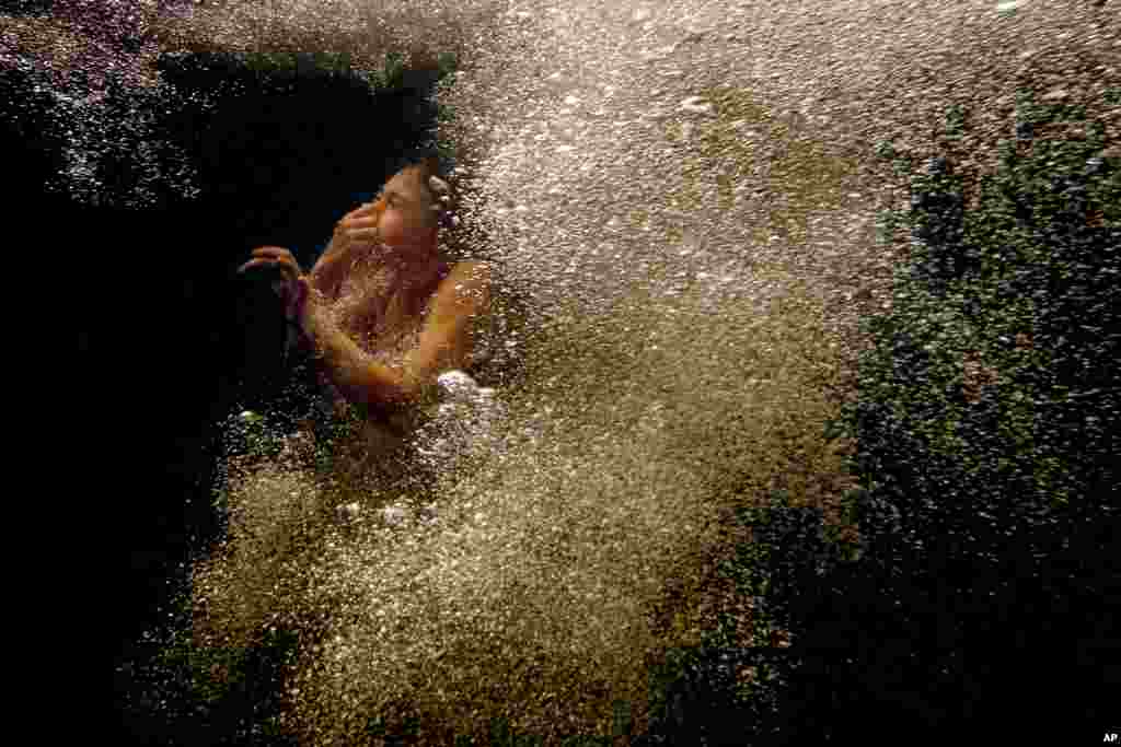 Marley Wentworth surfaces through bubbles after jumping into the Mousam River at Indian's Last Leap, a popular swimming hole in Springvale, Maine, Aug. 11, 2020.