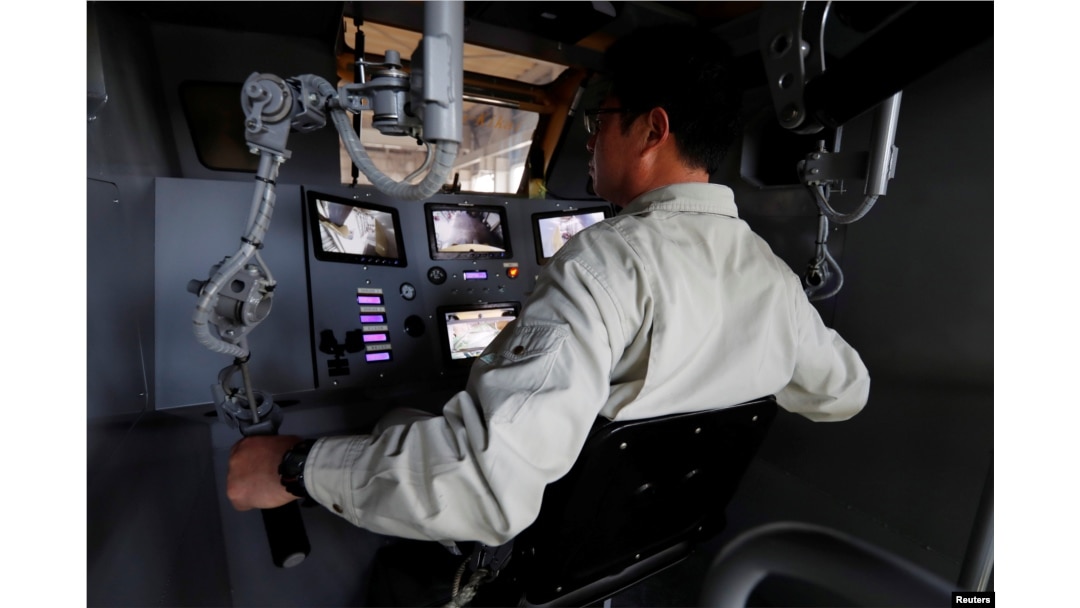 Sakakibara Kikai's engineer Masaaki Nagumo controls the bipedal robot Mononofu from its cockpit