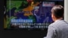 A man watches a television screen showing a news report on North Korea firing several short-range projectiles from its east coast, on a street in Tokyo, May 4, 2019. 