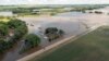 Un agente de la patrulla de caminos de Dakota del Sur observa un puente inundado tras días de fuertes lluvias en la zona, cerca de Lake Alvin, Dakota del Sur, el sábado 22 de junio de 2024.