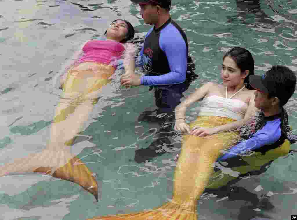 Para instruktur renang memberikan latihan renang untuk anak-anak dan orang dewasa degan mengenakan kostum putri duyung yang merupakan daya tarik terbaru di oceanarium terbesar di negara itu, di Manila, Filipina. 