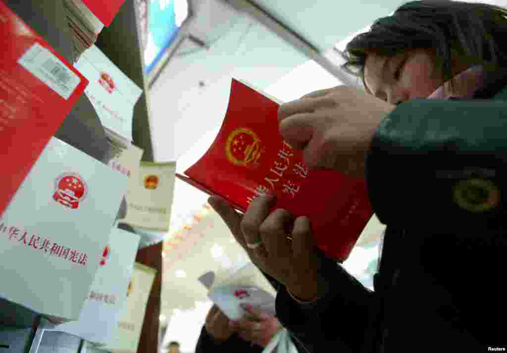 有人在北京书店阅读中国宪法。2004年，江泽民的三个代表思想写入中国宪法。