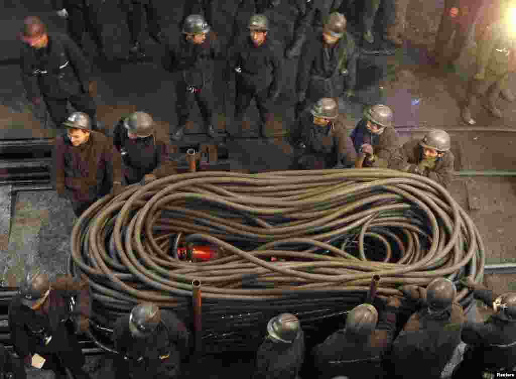 Miners transport cables to ensure electric power supply at the entrance of the Jiaojiazhai coal mine in Xinzhou, north China's Shanxi province, where 19 miners died in a gas blast, Nov. 8, 2006. (Reuters)