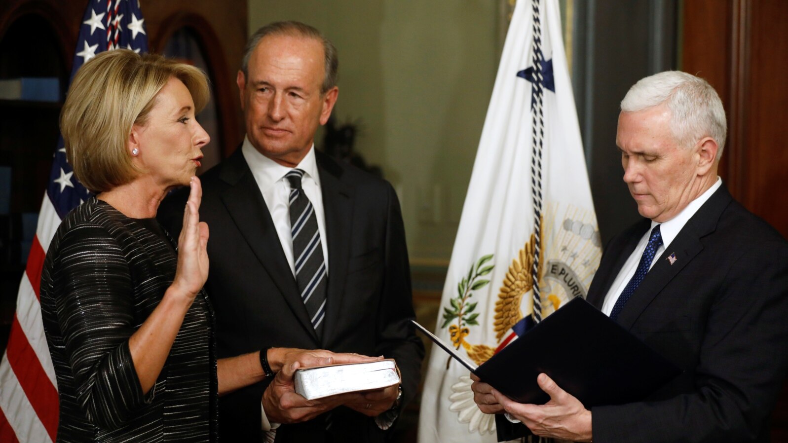 Vice President Mike Pence swears in Betsy DeVos as U.S. education secretary at the Eisenhower Executive Office Building at the White House in Washington, Feb. 7, 2017. With them is DeVos' husband, Dick DeVos.