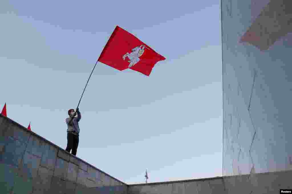 A man waves a flag during an opposition demonstration to protest against presidential election results at the Independence Square in Minsk, Belarus.