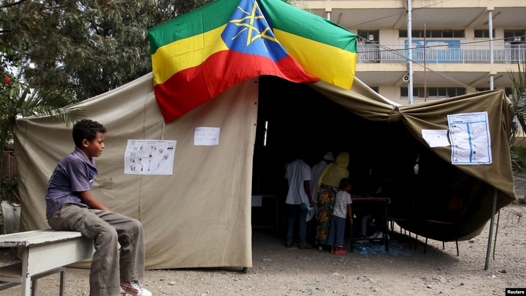 A boy sits outside a polling station, as Ethiopia's national election kicks off in capital Addis Ababa, May 24, 2015. 