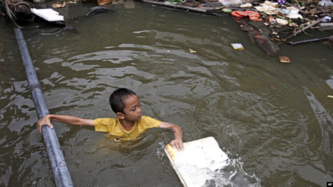 A Thai boy in a flooded area in Bangkok, Thailand. Hundreds of people died across Southeast Asia, China, Japan and South Asia in the last four months from prolonged monsoon flooding, typhoons and storms in October 2011.