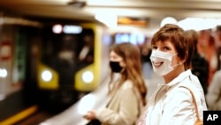Passengers with face masks wait for a train at the Alexanderplatz underground station in Berlin, Germany, April 27, 2020.