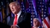 FILE - Vice president-elect Mike Pence, right, watches as President-elect Donald Trump speaks during an election night rally in New York, Nov. 9, 2016.