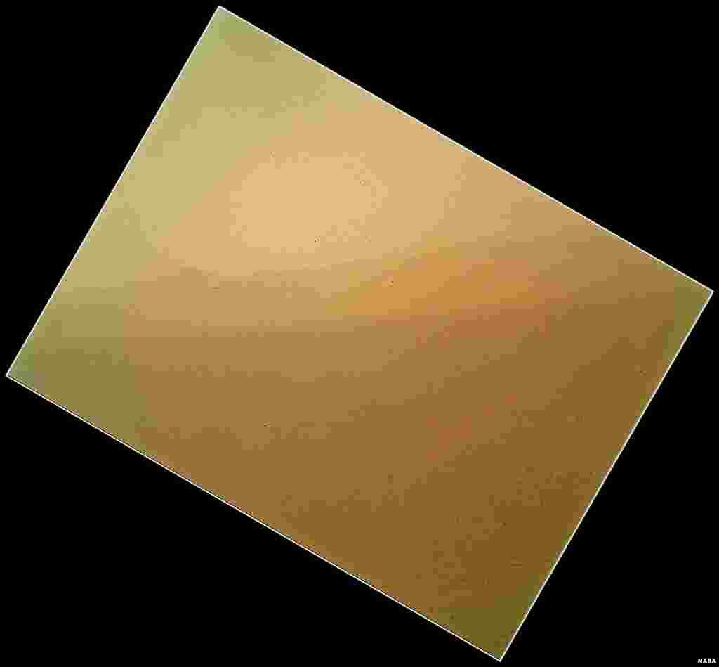 The image shows the north wall and rim of Gale Crater in the distance. The image shown here has been rotated to correct for that tilt, so that the sky is up and the ground is down.