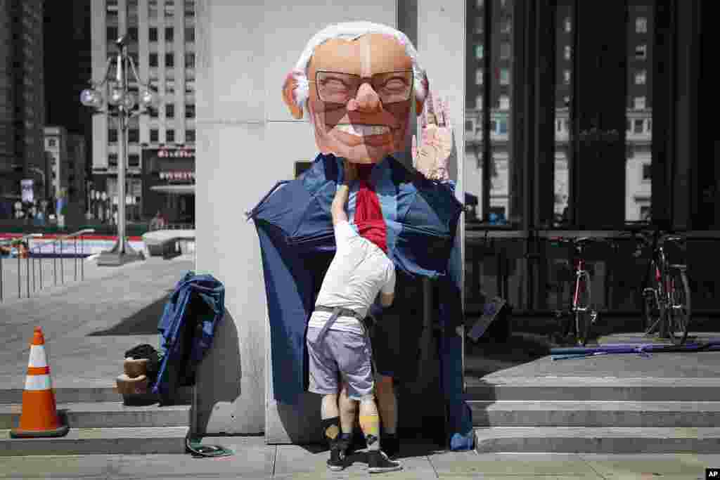Alex Schaefer of Los Angeles prepares a giant Sen. Bernie Sanders, I-Vt., before a march during a protest in downtown Philadelphia, July 24, 2016.