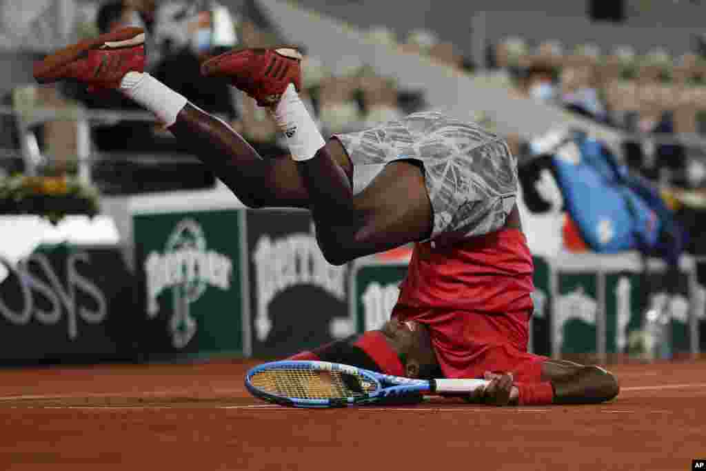 Mikael Ymer of Sweden slips and falls in the first round match of the French Open tennis tournament against Serbia's Novak Djokovic at the Roland Garros stadium in Paris, France.