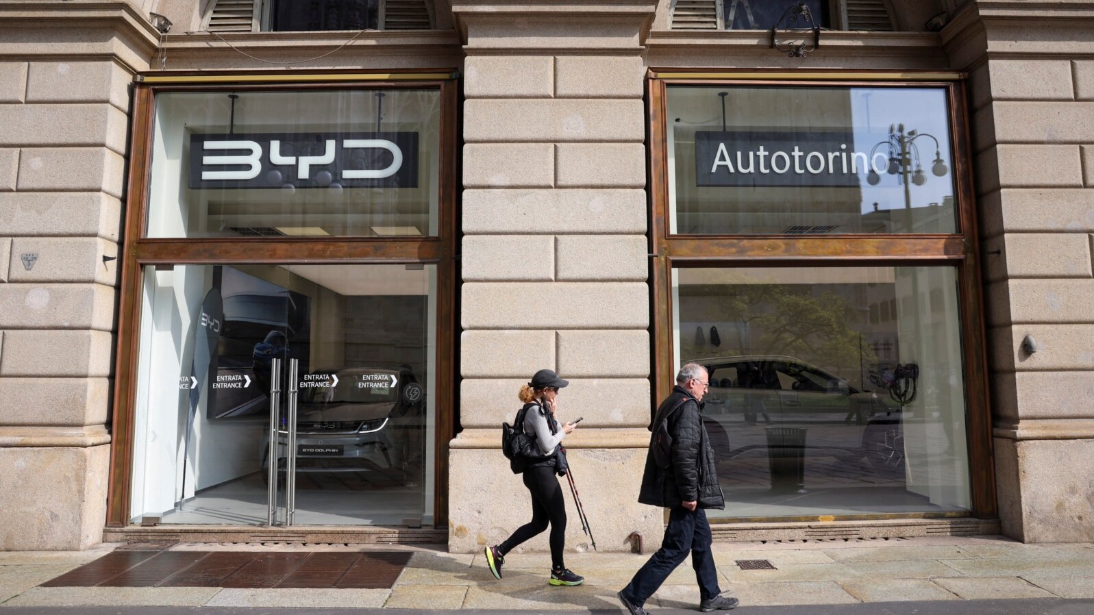 FILE - People walk in front of a store opened by Chinese electric car maker BYD in Milan, Italy, on March 20, 2024.