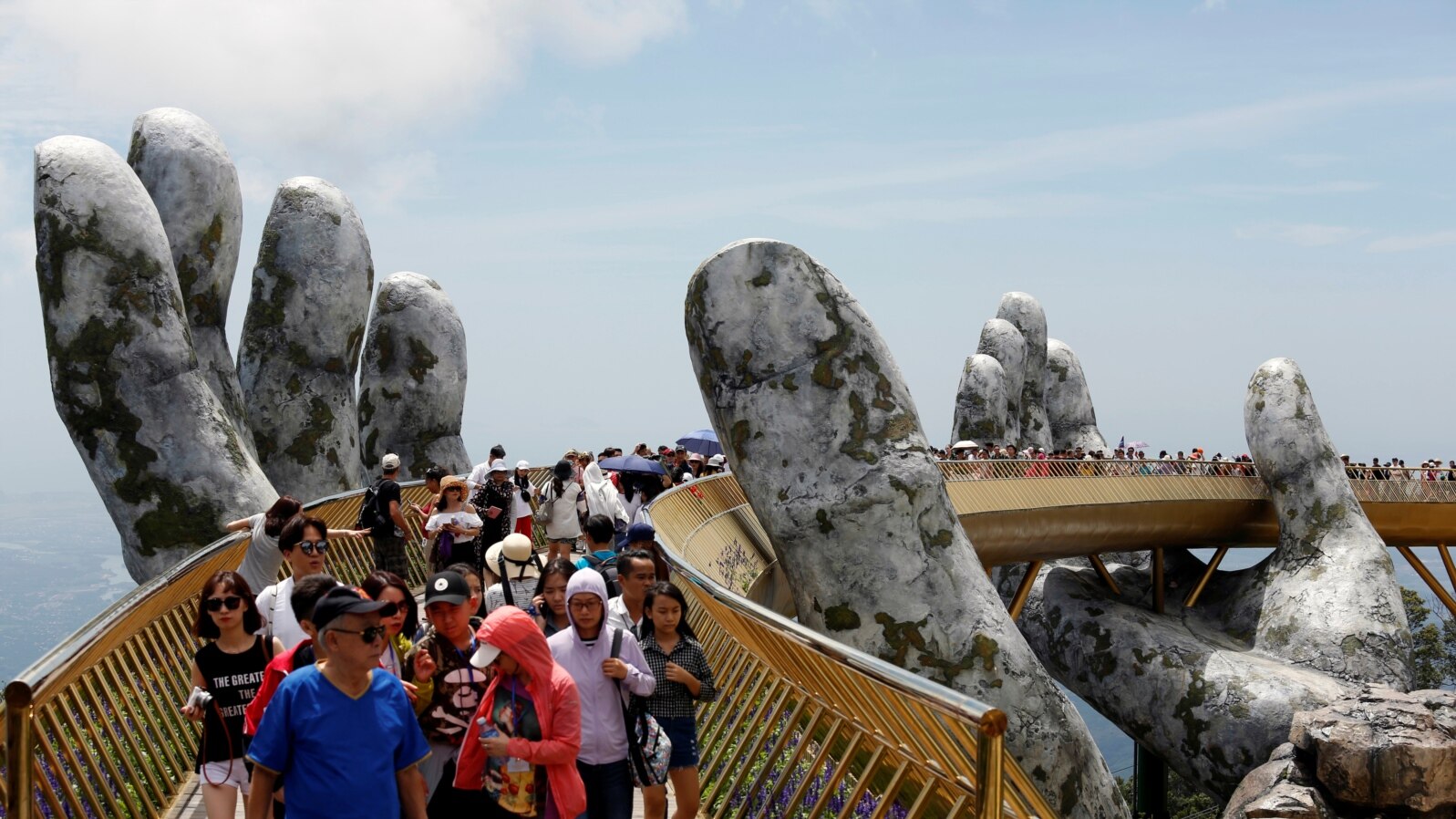 Tourists walk along Gold Bridge on Ba Na hill near Danang city, Vietnam, Aug. 1, 2018. 