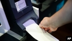 In this June 13, 2019, photo, Steve Marcinkus, an Investigator with the Office of the City Commissioners, demonstrates the ExpressVote XL voting machine at the Reading Terminal Market in Philadelphia. An analysis by The Associated Press has found…