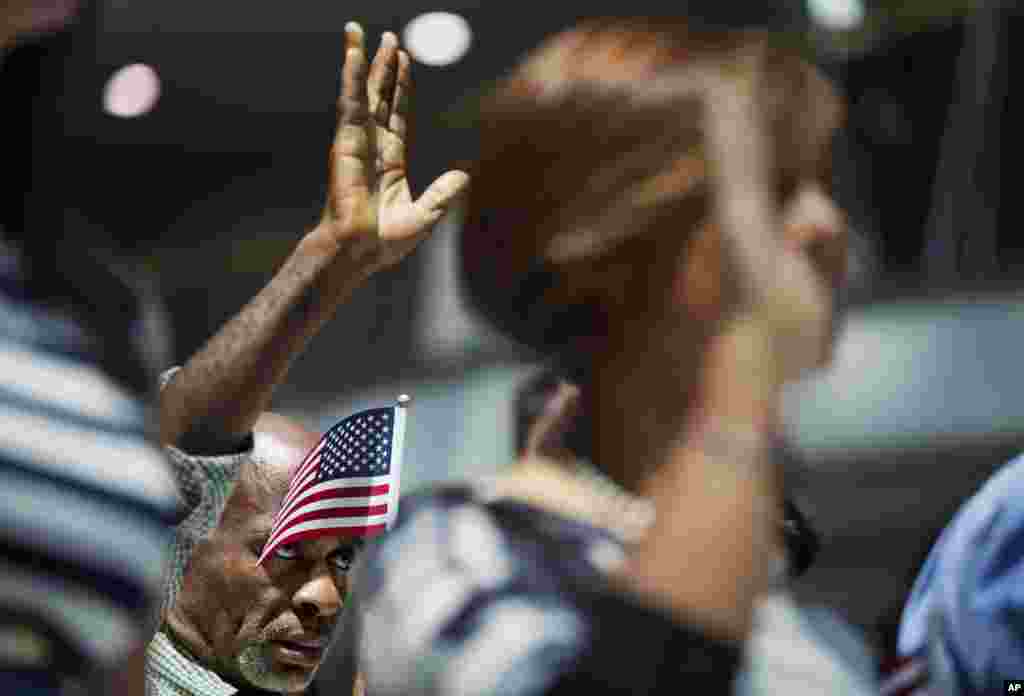 Mamadou Lawal Diallo, asal Guinea, mengangkat Oath of Allegiance (Sumpah Setia) pada acara naturalisasi di Atlanta, Georgia. Sembilan belas warga baru Amerika mengangkat sumpahnya sebagai WN AS di Balai Kota sebelum libur peringatan 4 Juli.