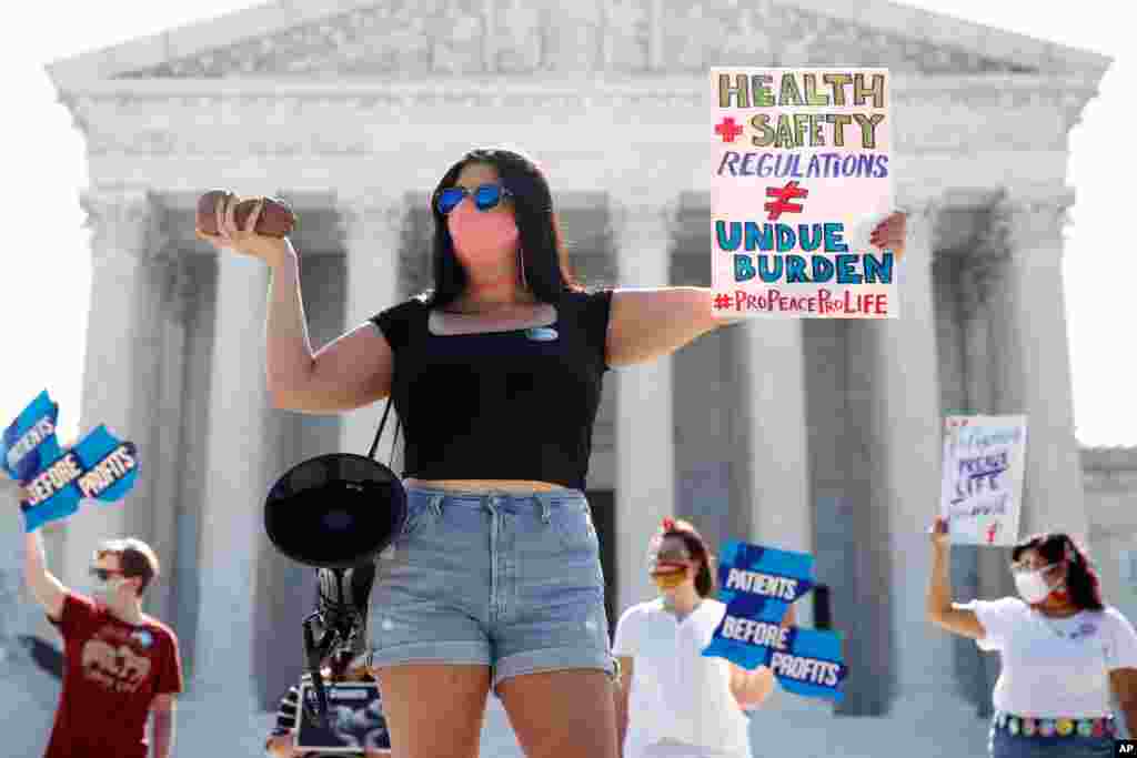 Terrisa Bukovinac, founder of Pro-Life San Francisco, holds a model of a fetus as she and other anti-abortion protesters wait outside the Supreme Court for a decision in Washington, D.C.