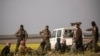 FILE - Men suspected of being Islamic State group fighters arrive at a screening point run by U.S.-backed Syrian Democratic Forces, where suspected jihadists, many of them wounded, were being interrogated outside Baghuz in northeastern Syria, March 6, 2019.