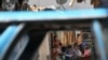 Enmarcada a través de la ventana de un automóvil abandonado, una mujer amamanta a su hijo en el barrio de Petare en Caracas, Venezuela. Octubre 17, 2020.