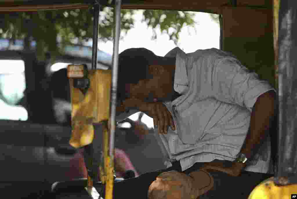 Tài xế lái xe lam ngồi nghỉ dưới thời tiết nóng bức ở Hyderabad, Ấn Độ, ngày 25/5/2015.