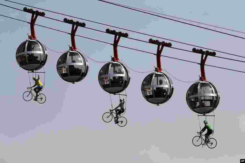 Performers dressed as riders pedal during the start of the stage 17 of the Tour de France cycling race over 170 kilometers (105 miles), between Grenoble and Meribel Col de la Loze.