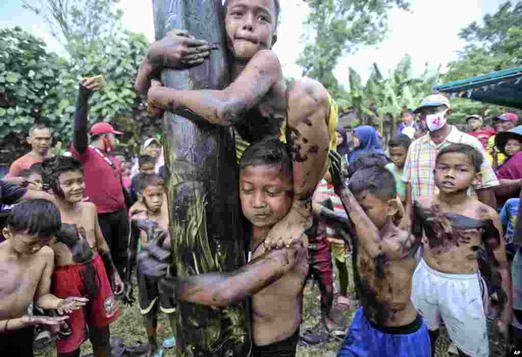 Children take part in a greased-pole climbing competition during the celebration of the 75th anniversary of the country's independence in Medan, North Sumatra, Indonesia.
